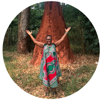 person standing with arms outstretched  infront of banyan tree